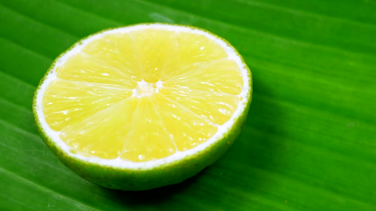 una rebanada de limón verde está girando lentamente en el estudio con los detalles.