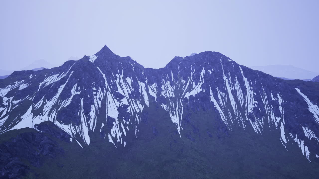 Cime innevate si ergono maestose su un paesaggio nuvoloso al crepuscolo