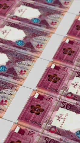 vertical video of 50 qatari riyal banknotes printed by a money press