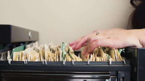 Secretaria-Hojeando-Carpetas-En-Un-Archivador