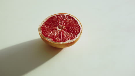 empuje pomelo en rodajas sobre una mesa de cocina blanca