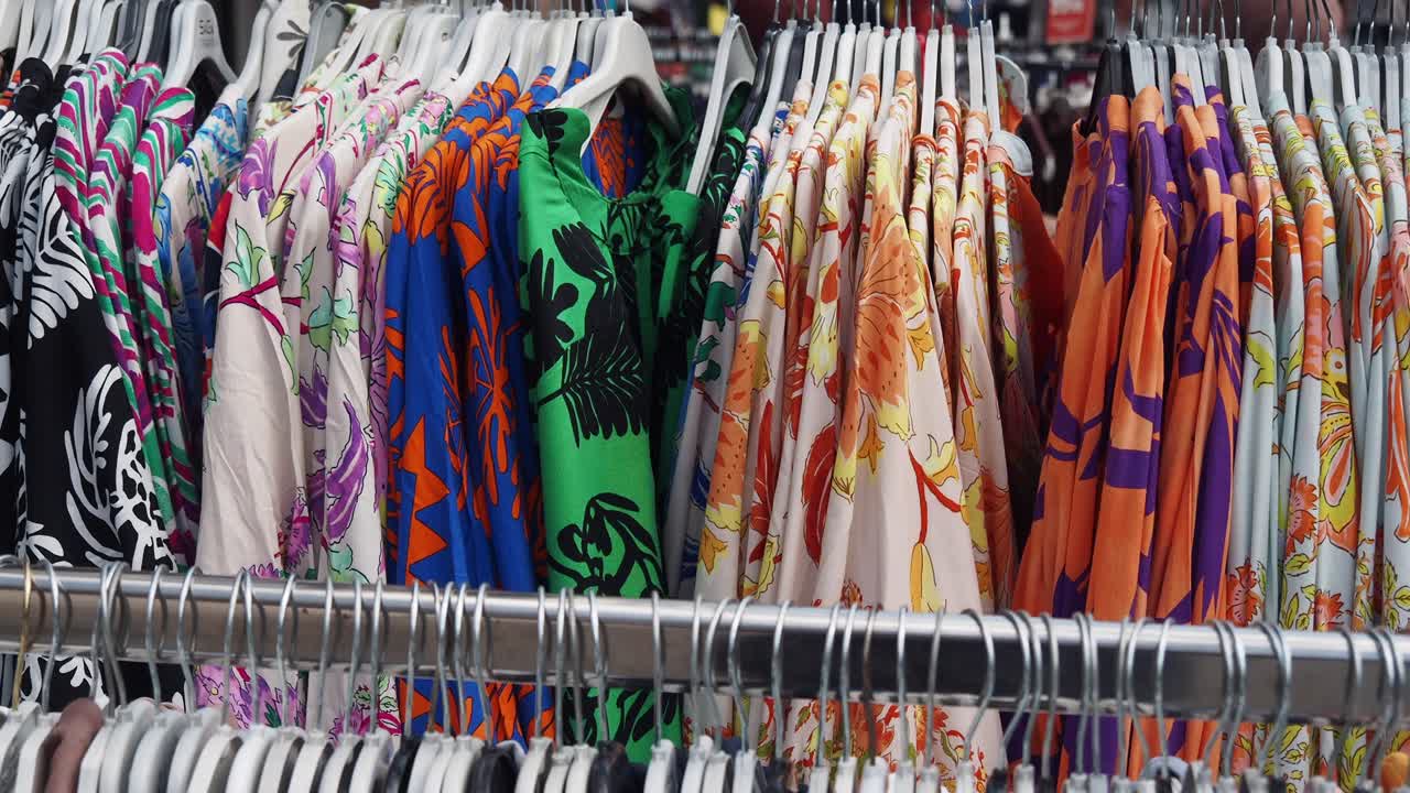 camisas con patrones florales coloridos en colgadores