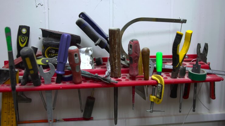 Workbench Tool Shelf With Assorted Hand Tools Lined On Red Organizer, Pliers, Screwdrivers, Hammer, Measuring. Media