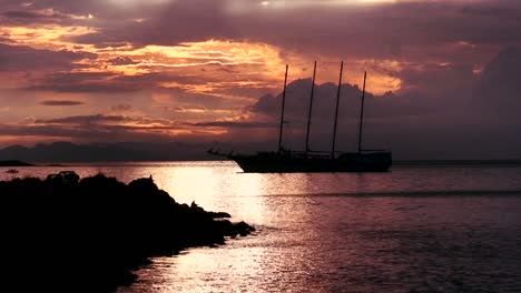 a beautiful sailing ship in a harbor at sunset