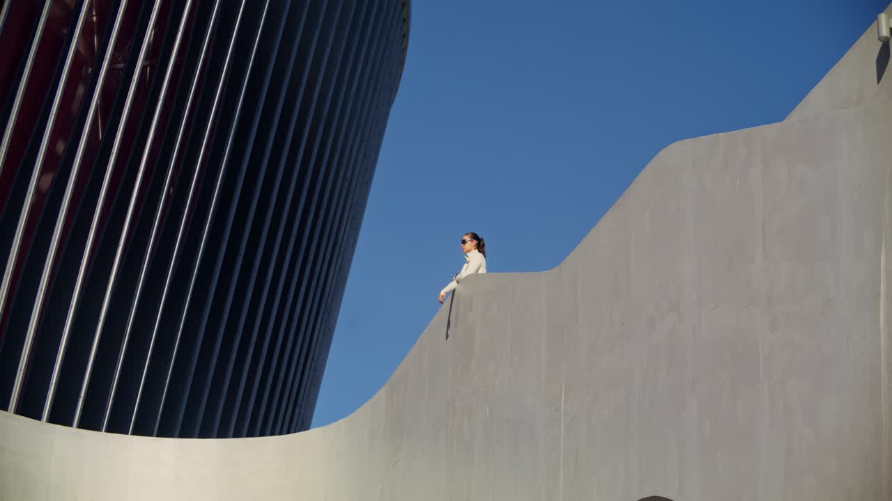 Woman in Sunglasses on Building Terrace