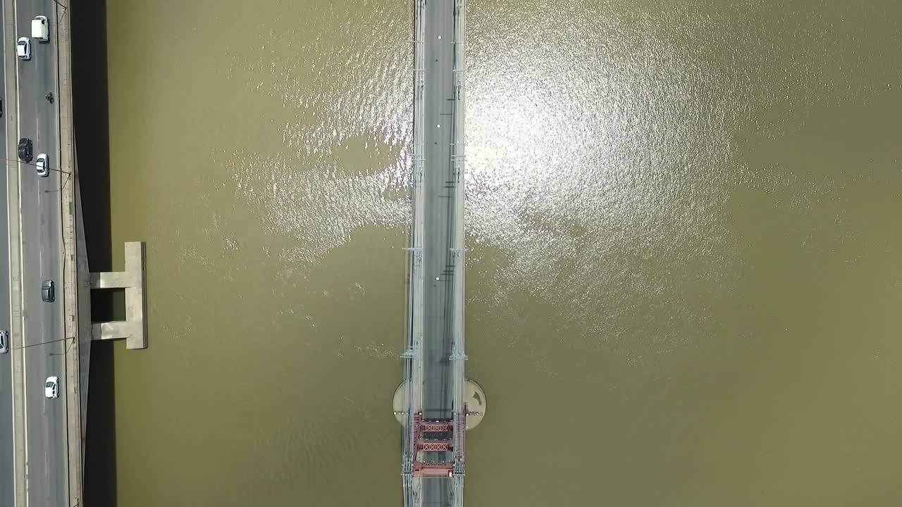 vista aérea de arriba hacia abajo del tráfico en suspensión y un puente moderno sobre el río en la ciudad de santa fe, argentina, disparo de drones de gran ángulo
