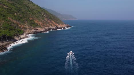 aerial tracking of a boat sailing at sea, close to a coastline