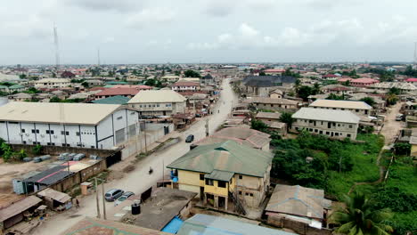 mowe town in nigeria's ogun state - view of a dirt road and a thriving west african city - ascending aerial view