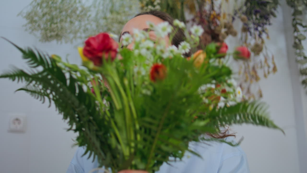 trabajador de floristería sostiene un ramo de flores en una hermosa tienda de plantas florales
