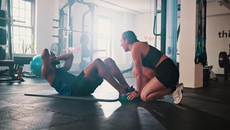 man and woman working out together in gym