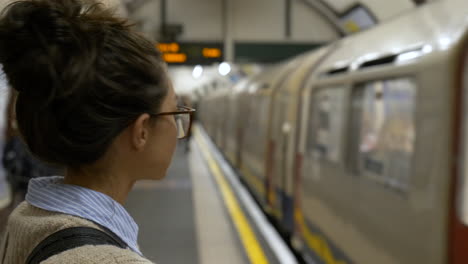 attractive young woman waits for london underground tube train