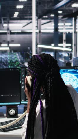 vertical video engineer in data center answers telephone call, assisting users with ai
