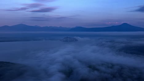 drone hyperlapse: janitzio island at sunrise with mist and clouds