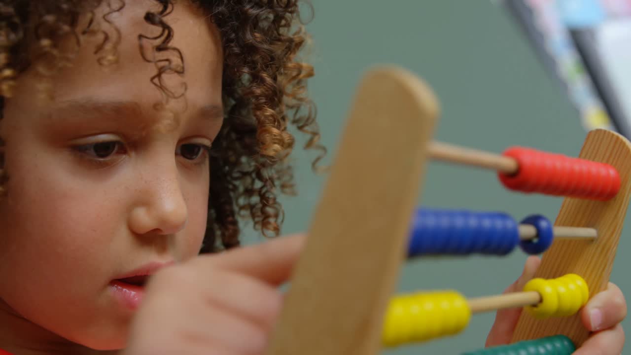 primer plano de una colegiala de raza mixta aprendiendo matemáticas con ábaco en un aula de la escuela 4k