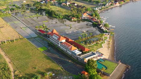 aerial-of-indonesian-resort-with-ocean-view-pool-on-coastline-of-Lovina-Bali-Indonesia-at-golden-hour-sunset