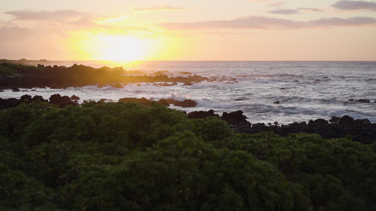 조용한 파도가 해안에 도달하는 바위 해변에서 조용한 일몰