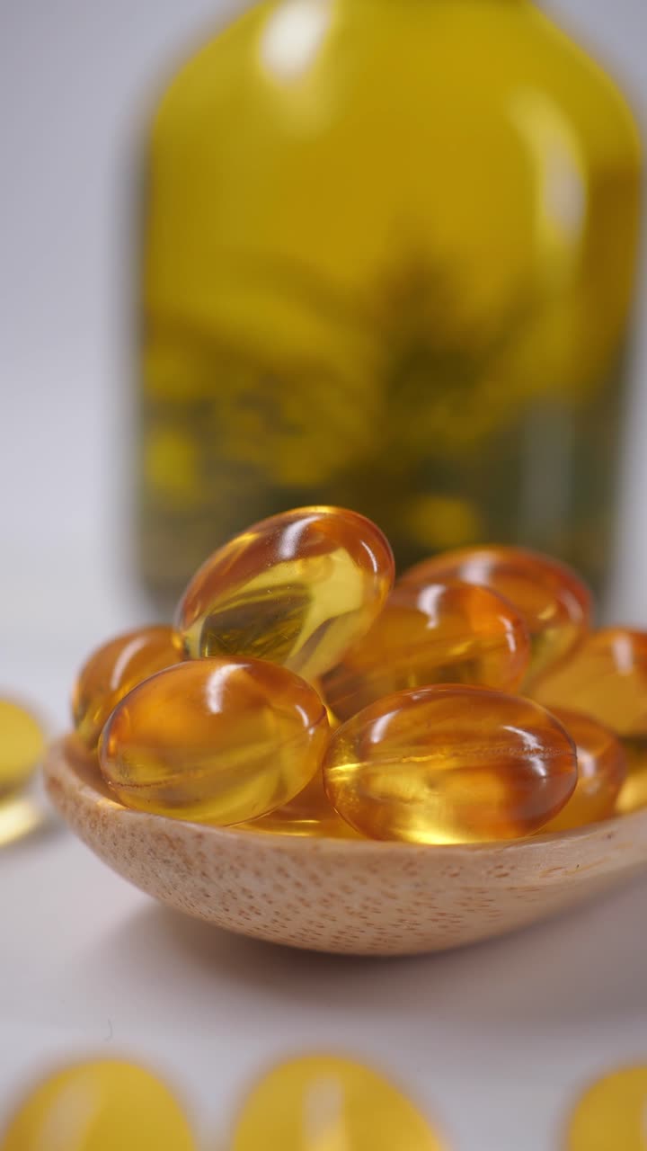 Capsule softgel dorate su cucchiaio di legno per la salute e il benessere