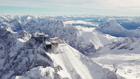 rotating aerial of the summit of zugspitze a mountain in the alps with an impressive building on top