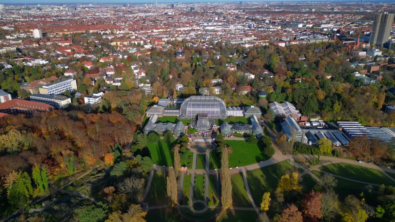 Berlin botanical garden tropical greenhouse glasshouses surrounded by autumn trees and city landscape. speed ramp hyper motion time lapse Amazing aerial view flight fly push forward drone