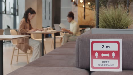 keep distance sign on couch in cafe