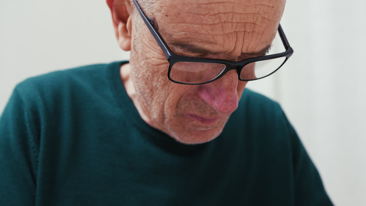 Senior Man With Glasses Focused While Doing Something, Close-Up