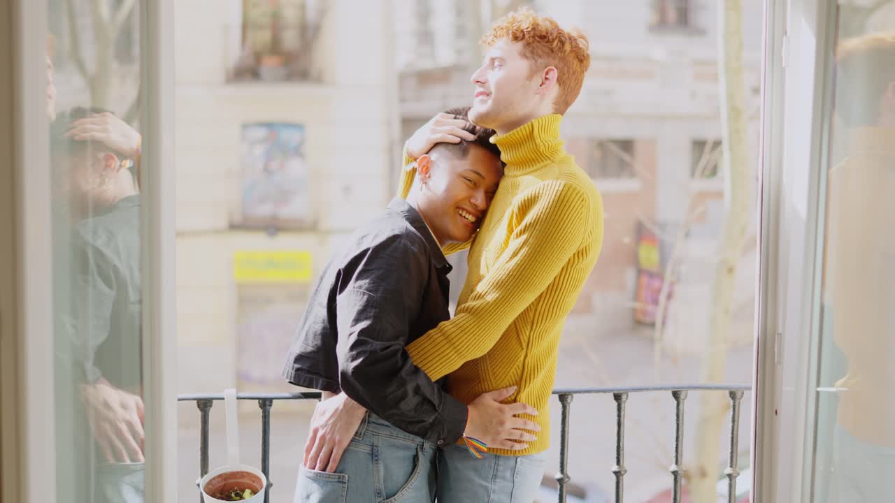 Happy Gay Couple Embracing on a Sunny Balcony