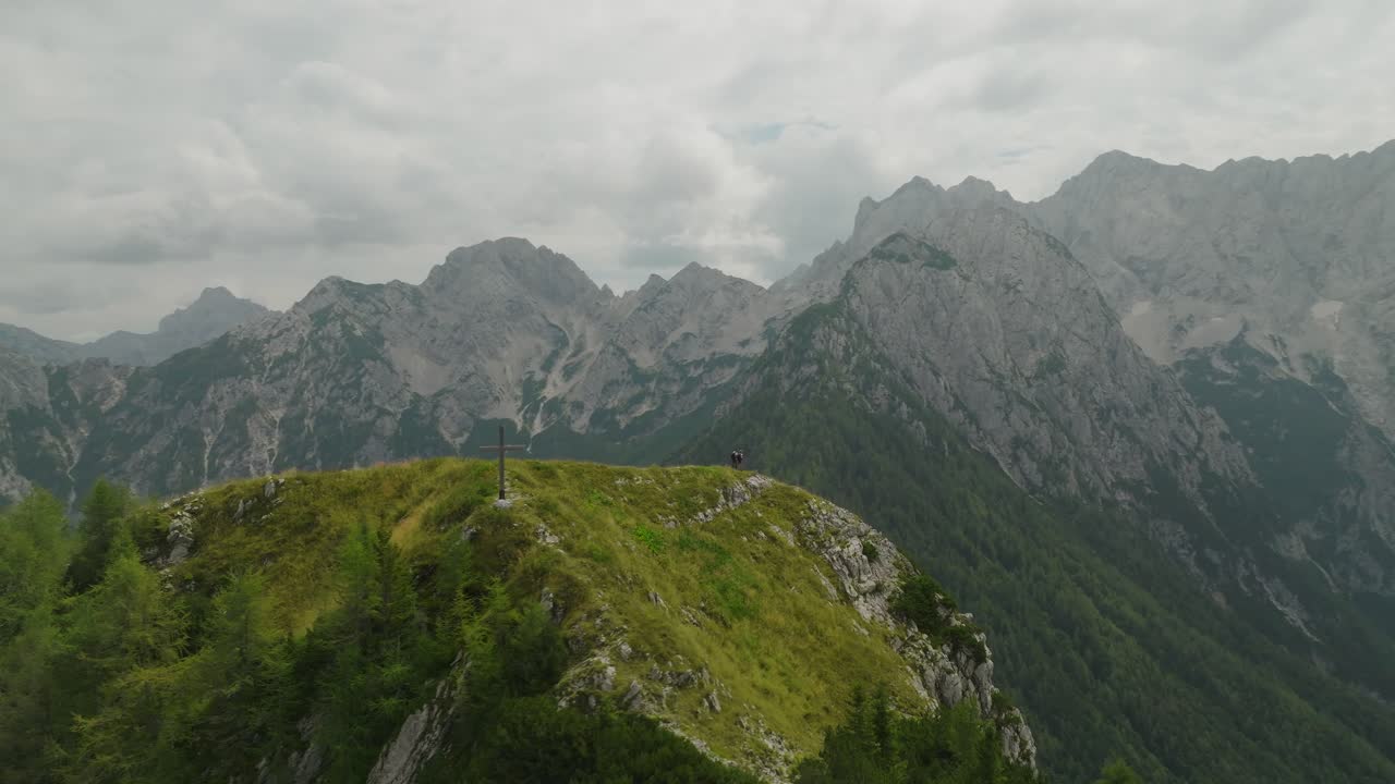 Couple enjoys stunning mountain views while hiking on Goli Peak in Slovenia under cloudy skies