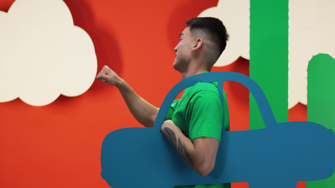 Man playing with a cardboard car prop