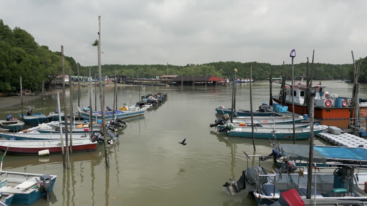 Calm Fishing Pier with Small Boats nestled in the Mangrove Forest Cloudy Day, Strait of Johor Malaysia Singapore Border Fishing Industry in the Johor Strait