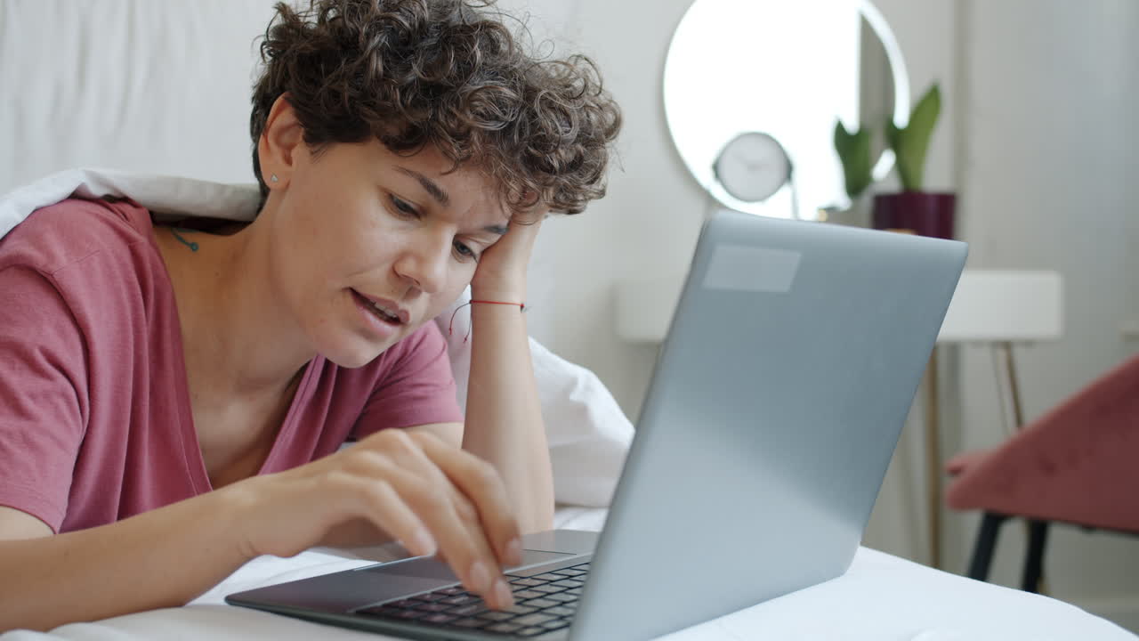 mujer trabajando en la computadora portátil en la cama