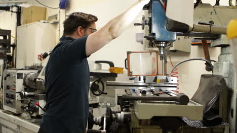 caucasian worker operating a milling machine in industrial workshop