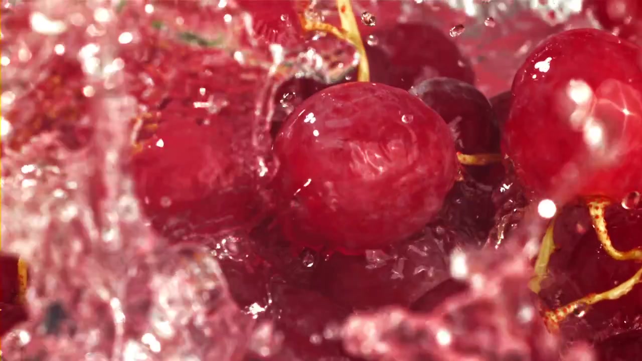 Uva rossa che schizza nell'acqua al rallentatore