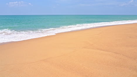 Zeitlupe-Von-Meereswellen,-Die-über-Den-Goldenen-Sand-Eines-Unberührten-Strandes-Spülen