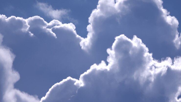 White Fluffy Clouds In Bright Blue Summer Sky - Low-Angle Shot