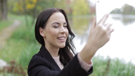 mujer tomando selfie cerca del estanque