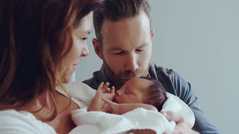 Front-view-of-Caucasian-couple-holding-their-newborn-baby-in-the-ward-at-hospital