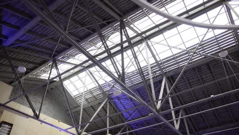 Modern-industrial-ceiling-with-event-light-on-it-during-overcast-cloudy-day-and-glass-on-the-roof-shot-on-gimbal-with-parallax-effect-in-4K