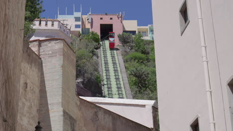 Guanajuato-Funicular-lift-decends,-view-from-street-level-between-buildings