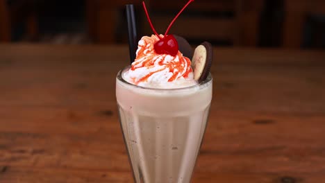 Detailed-close-up-of-chocolate-milkshake,-with-caramel,-espresso-and-whipped-cream-and-caramel,-tilt-up-and-down