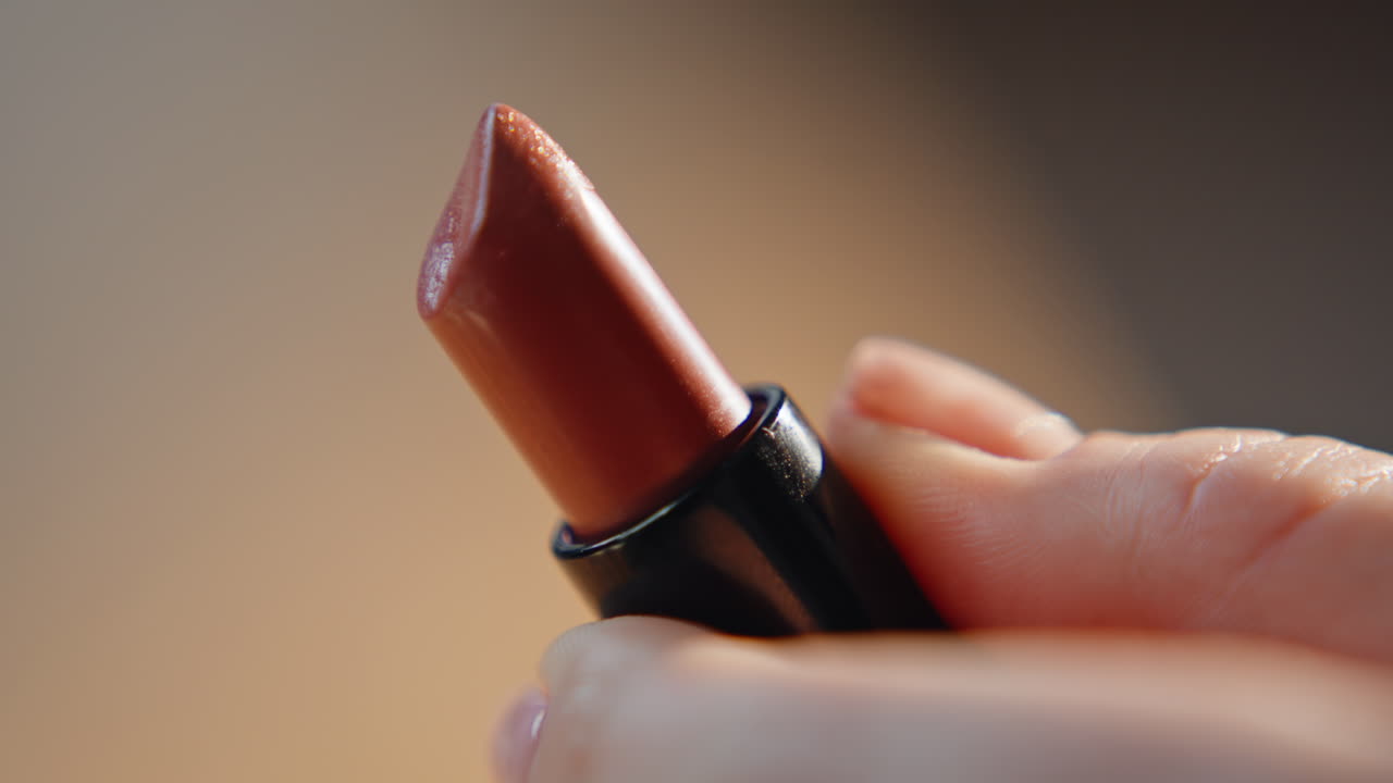 Hands opening red lipstick at morning makeup routine closeup. Decorative product