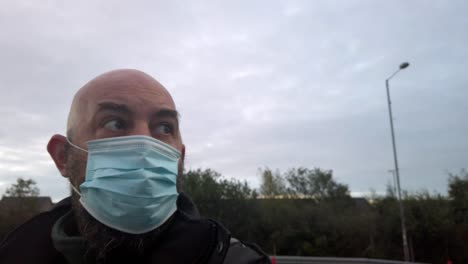 male in workplace wearing uniform and ppe face mask against corona virus looking around