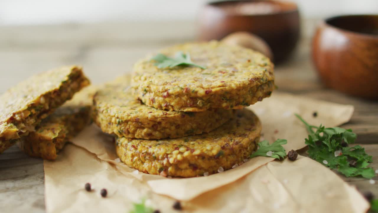 Video di foglie fresche e hamburger vegetariani con ciotole su sfondo di legno