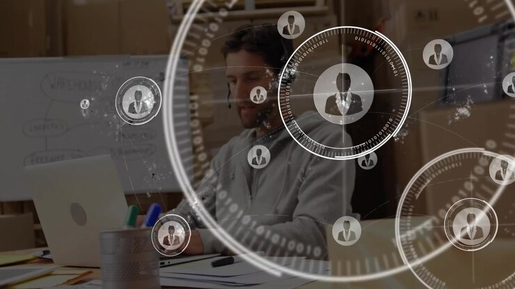 Office worker typing on laptop and initiating profile icons for viewing technology network links