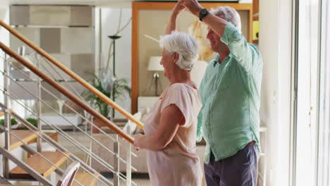 Happy-senior-caucasian-couple-dancing-together-at-home