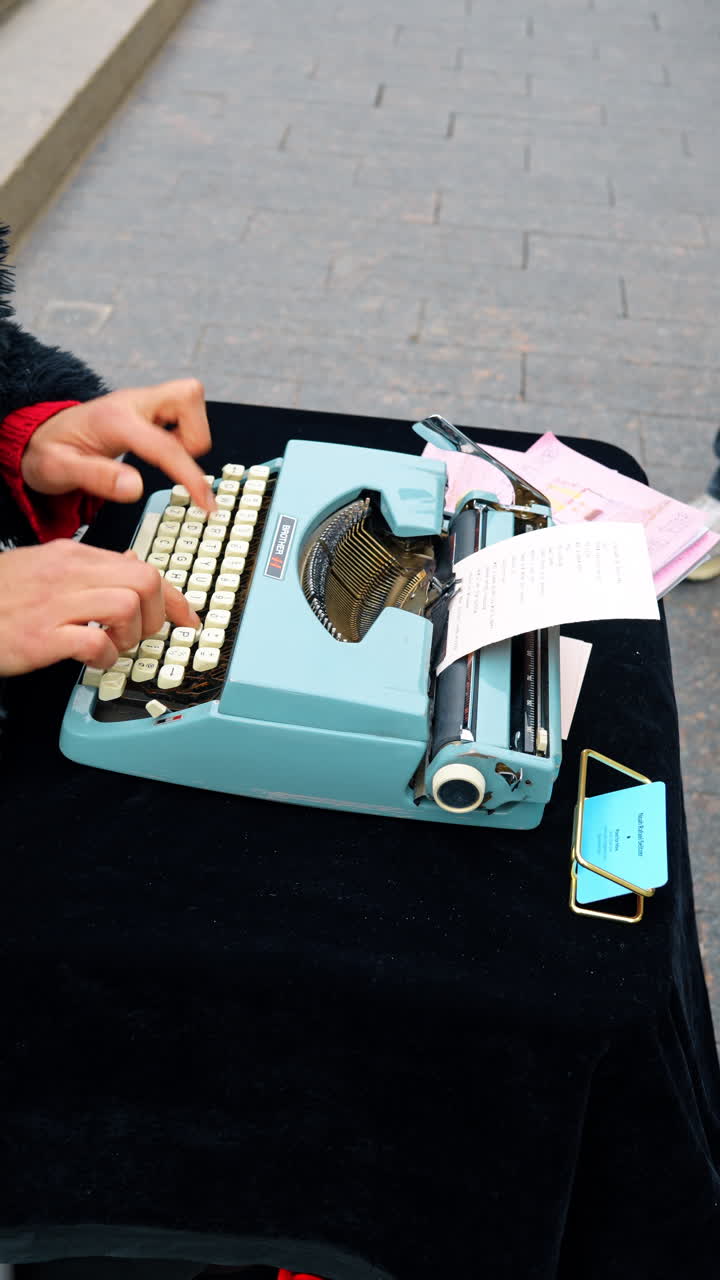 New York, USA, 2 marzo 2026: Primo piano di una persona che digita su una macchina da scrivere vintage blu. Veduta dall'alto delle mani sui tasti di una macchina da scrivere meccanica con una poesia stampata su carta.