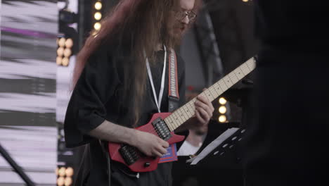 man playing red guitar on stage