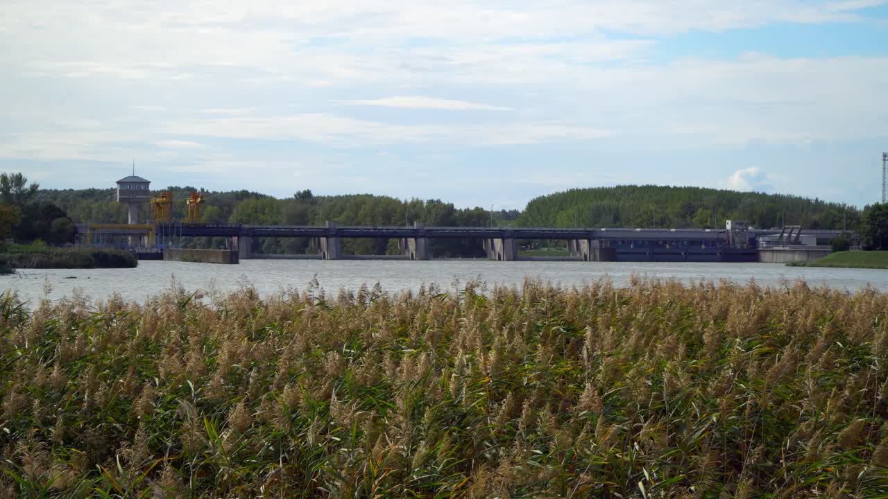 The fascinating architecture of the Kiskore Hydroelectric Power Plant complex and the surrounding forests at Lake Tisza, from a distance in Hungary.