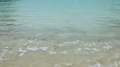 soft waves gently washing onto sandy beach in krabi, thailand