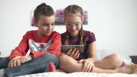 hermano y hermana viendo dibujos animados en el teléfono móvil en casa
