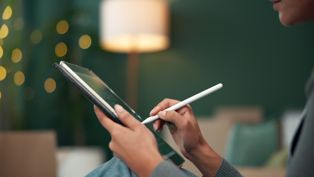 Donna che usa un tablet con uno stilo a casa